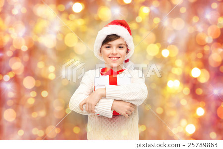 图库照片: smiling happy boy in santa hat with gift box
