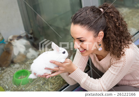 图库照片: girl holding the rabbit at pet shop.