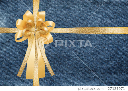 照片素材(图片): golden ribbon and bow, wrap on blue denim jeans