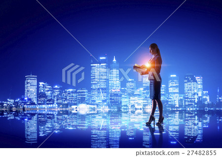 图库照片: rear view of businesswoman looking at night city