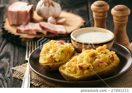 图库照片: baked potatoes with bacon, cheese and parsley.