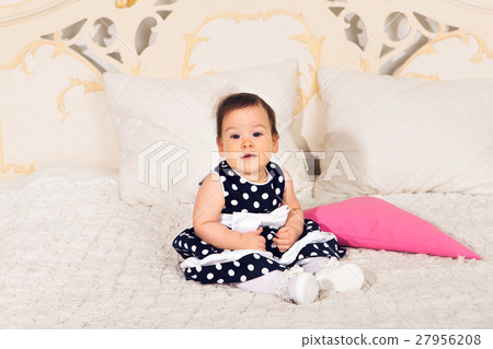 图库照片: sweet baby girl sit in bed