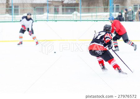 图库照片: ice hockey player with stick skating on the rink.