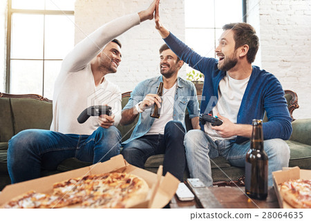 图库照片: positive male friends giving high five