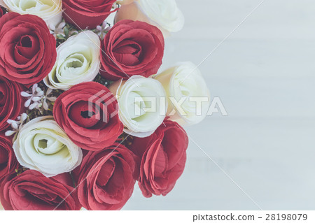 图库照片: bouquet of artificial rose flower on wooden plank.