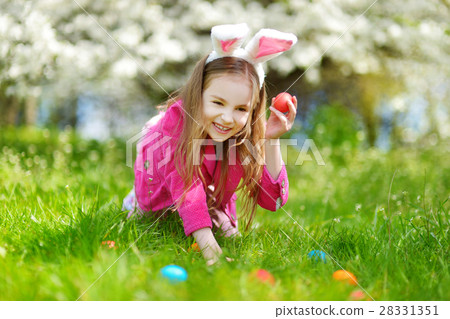 图库照片: adorable little girl hunting for easter egg on easter