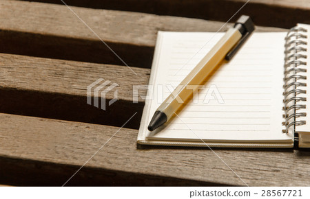 图库照片: a blank notebook page and pen on wood table.
