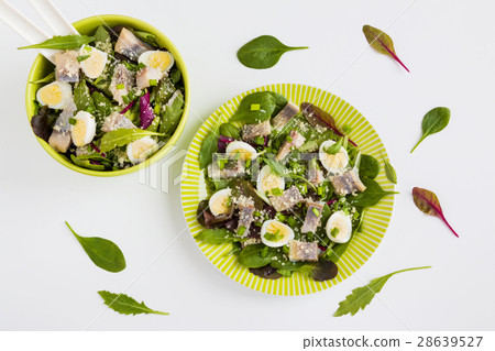 图库照片: pickled herring, mix of green salad, onion, eggs