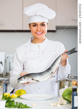 图库照片: female cook preparing big fish