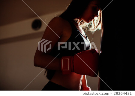 照片素材(图片): sexy fighter girl in gym with boxing bag