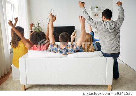 watching,seeingwatching 图库照片: happy friends with beer watching tv at home