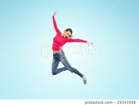 图库照片: happy young woman jumping in air or dancing