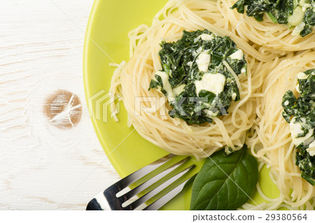 图库照片: italian pasta with spinach and feta on green plate