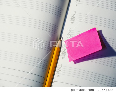 图库照片: pencil on music note book with post it paper