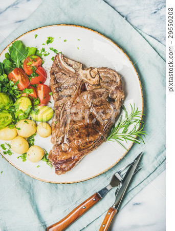 图库照片: meat dinner plate with cooked beef t-bone steak