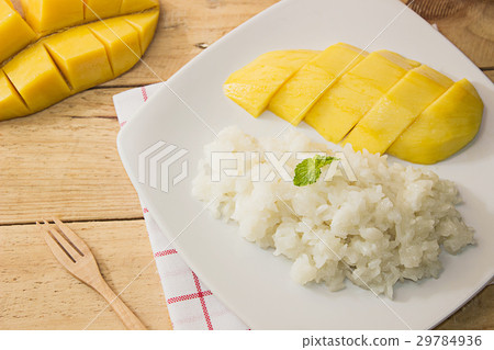 图库照片: fresh mango and sticky rice on white dish on wood