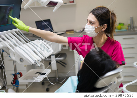 图库照片 female dentist showing woman's teeth on the screen