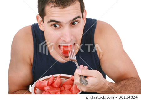 图库照片: young man eating a fresh water melon.