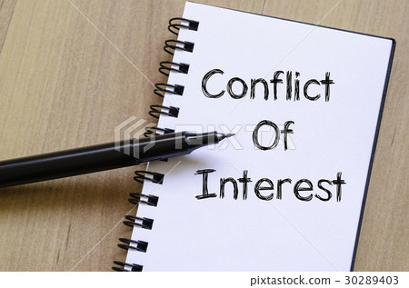 图库照片: conflict of interest write on notebook