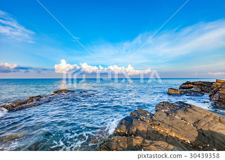 图库照片: rocky seashore in sunrise with bright blue sky