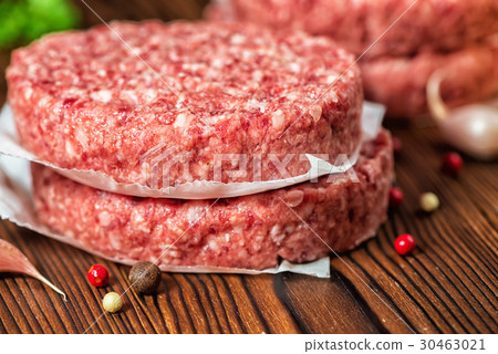 图库照片: raw ground beef meat hamburger patties on paper