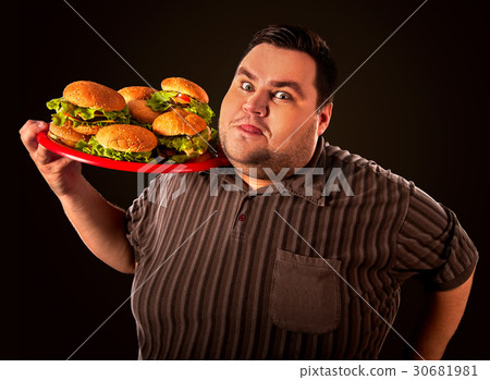 图库照片: fat man eating fast food hamberger. breakfast for