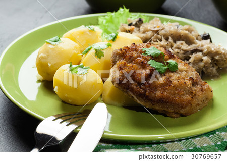 图库照片: fried pork schnitzel served with boiled potatoes