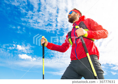 图库照片: man with sticks between nordic walking with sky back