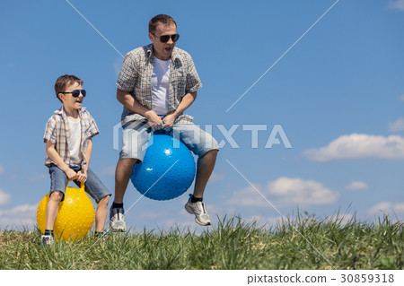 图库照片: father and son playing on the field at the day time.