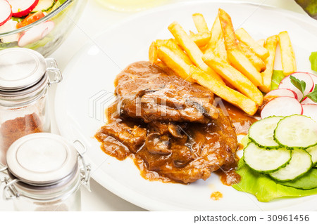 图库照片: pork chop with sauce, mushrooms and chips