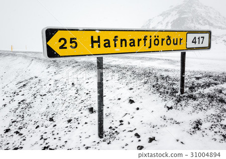 图库照片: yellow icelandic road sign in snowy day