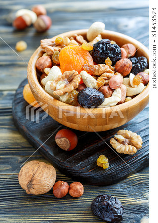 图库照片: dried fruit and mixed nuts in a wooden bowl.