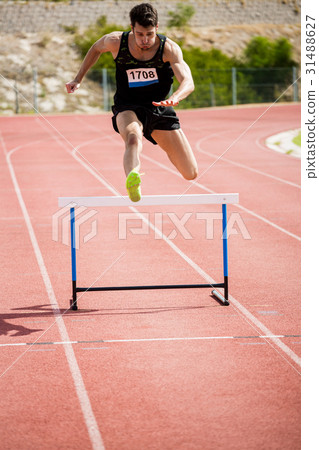 图库照片: athlete jumping above the hurdle