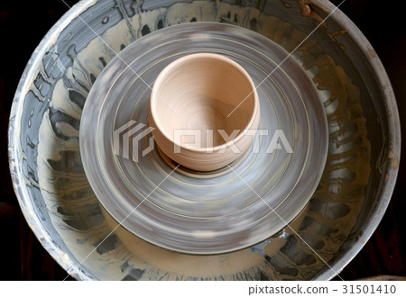 照片素材(图片): raw clay pot on a potter"s wheel