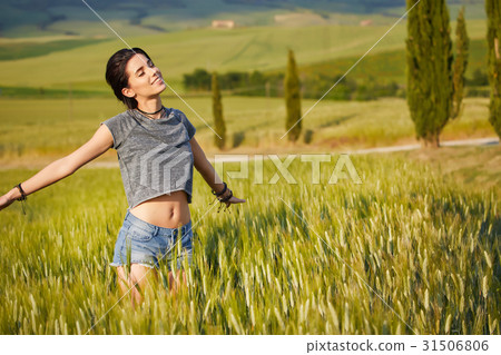 woman is walking along the road among the fields and a typical t