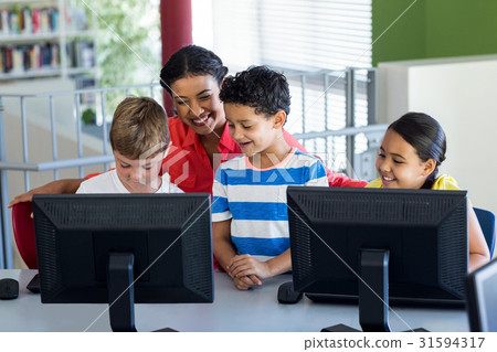图库照片: female teacher with children during computer class