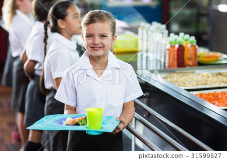 图库照片: cute schoolgirl with classmate standing near canteen