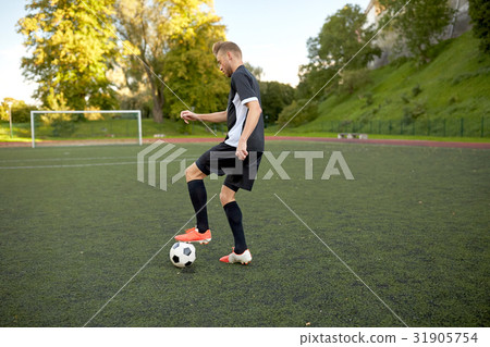 图库照片: soccer player playing with ball on football field