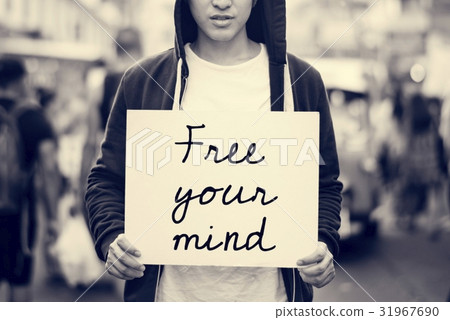 图库照片: asian guy holding placard free your mind motivation