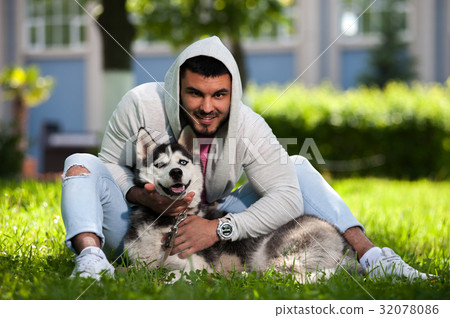 照片素材(图片): smiling happy guy with his husky dog in park