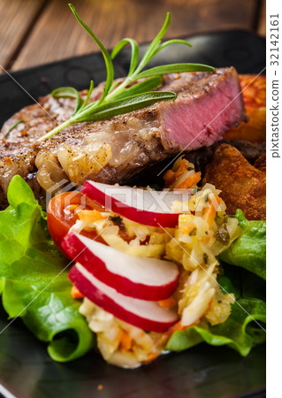 图库照片: portion of beef steak served with roast potatoes