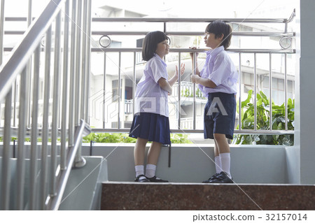 图库照片: two students are standing and talking in hallway at