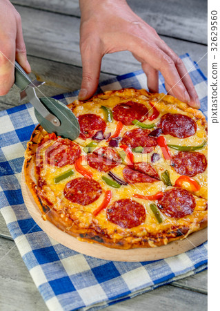 图库照片: cutting pepperoni pizza on sliced.