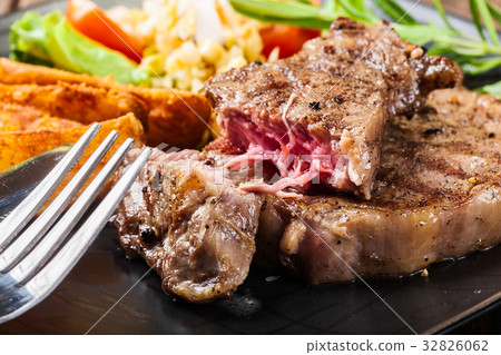 shinofbeef,beefshin 图库照片: portion of beef steak served with roast potatoes