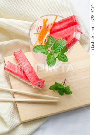 图库照片: crab stick with sliced carrot and radish in glass