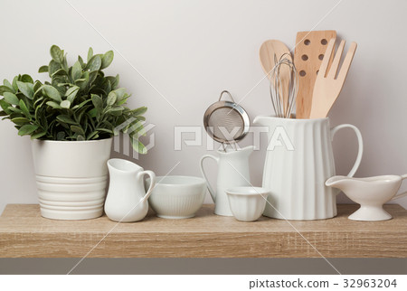 图库照片: kitchen utensils and dishware on wooden shelf.