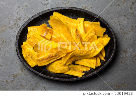 图库照片: healthy homemade banana plantain chips on black