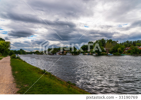 图库照片: wide river and houses on the shore, moored boats