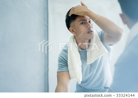 stock photo: a handsome man is looking at the mirror and