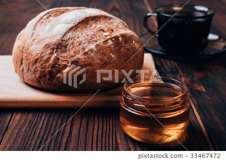 图库照片: bread, cup of tea and honey on a brown table